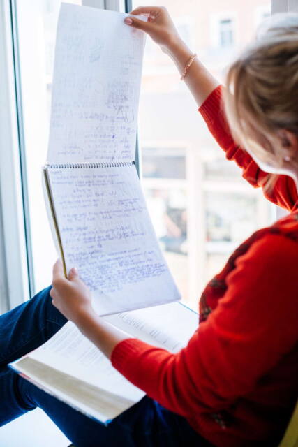 Mujer de rojo leyendo notas matemáticas