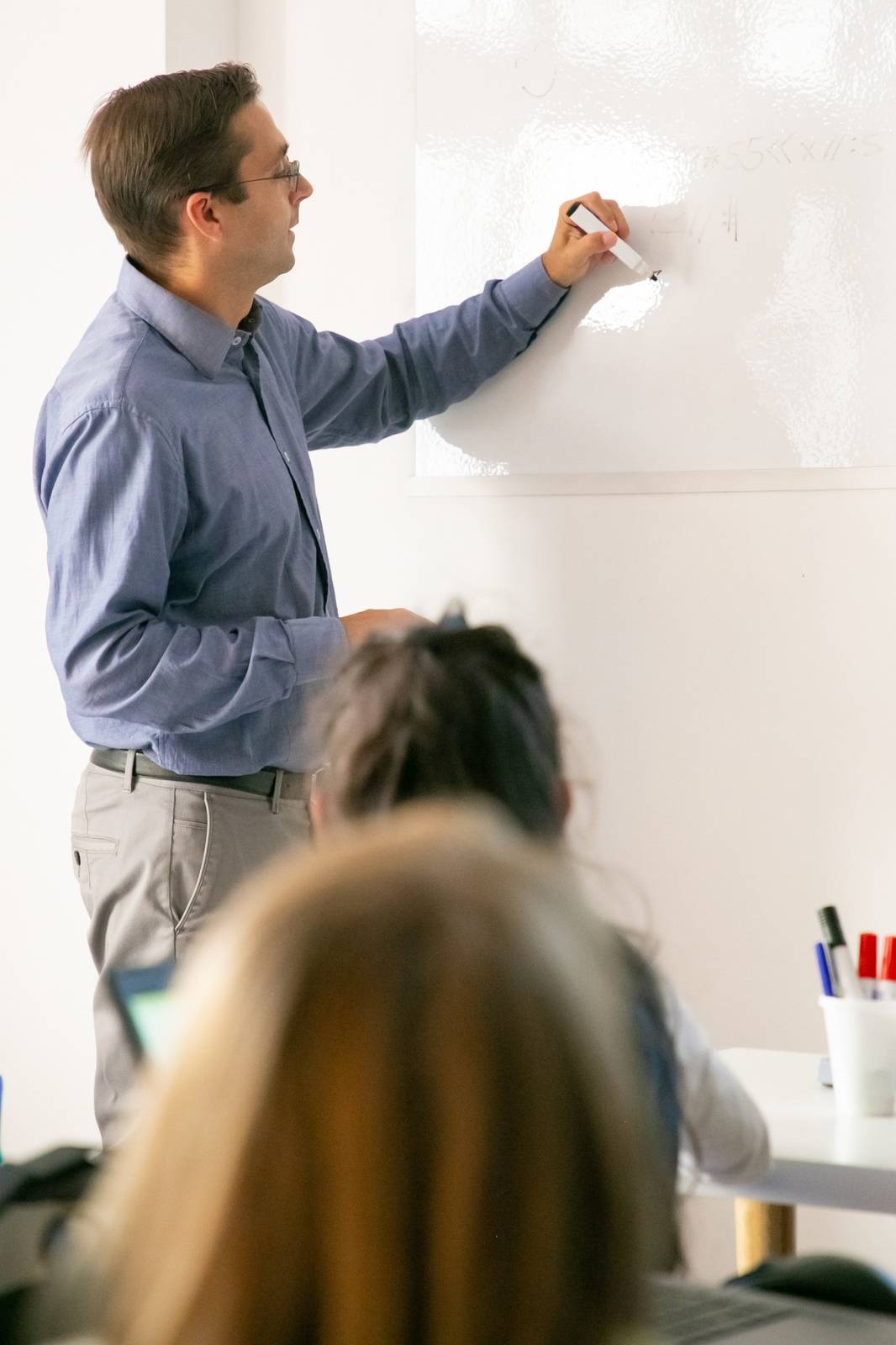 profesor particular explicando matemáticas en pizarra blanca